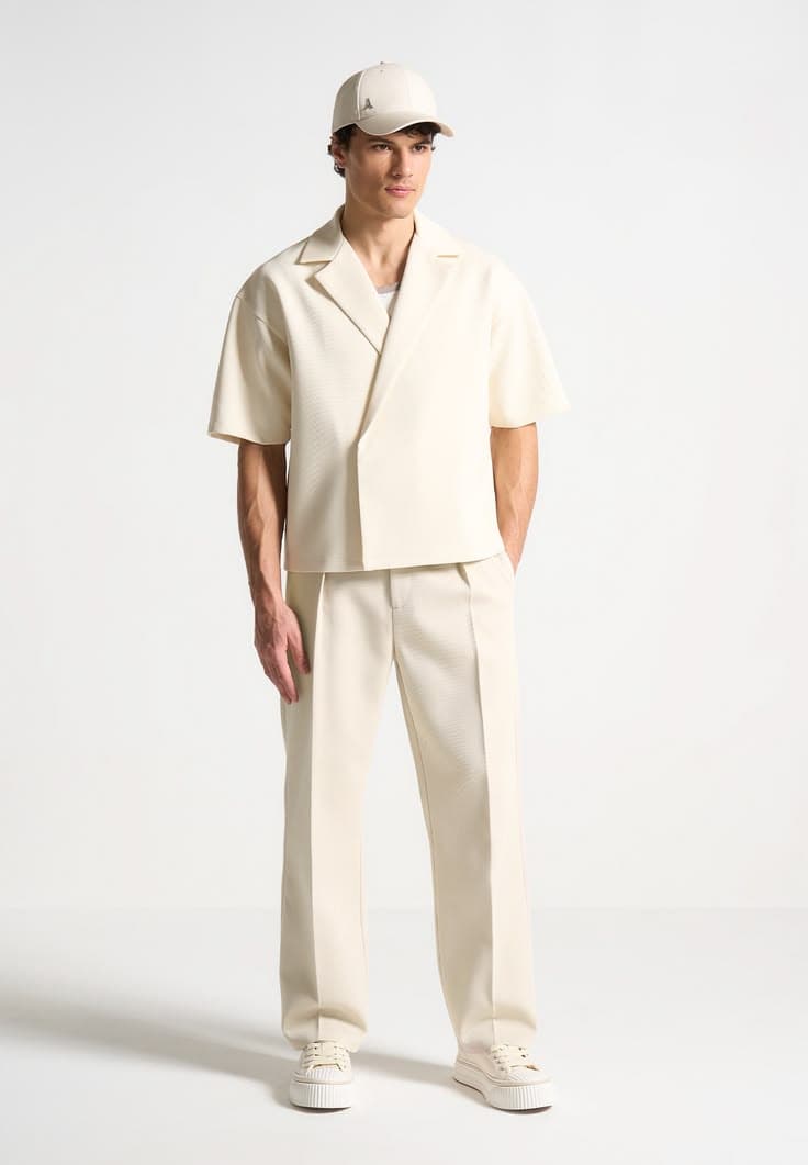 Cream boxy double-breasted shirt-jacket and matching wide-leg trousers with a cap